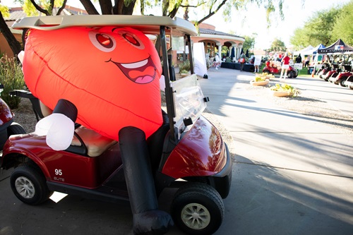 Blow-up Hearty Mascot sitting in a golf cart